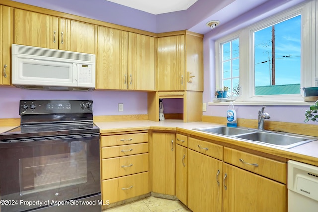 kitchen featuring sink, light tile patterned floors, and white appliances