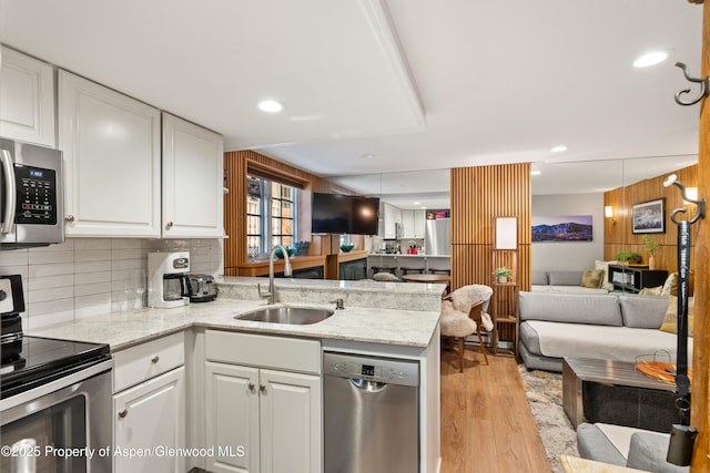 711 S Galena St Unit 17D, Aspen, CO 81611 - kitchen featuring white cabinets, a sink, light wood-style flooring, stainless steel appliances, and open floor plan