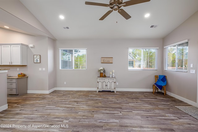 interior space with ceiling fan, vaulted ceiling, and light wood-type flooring