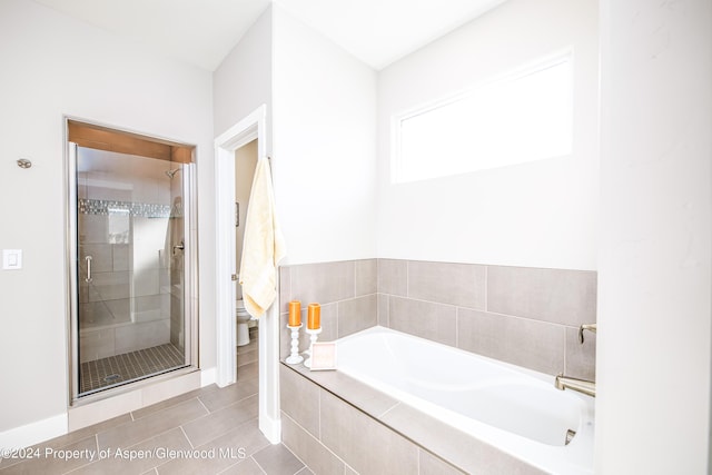 bathroom with tile patterned floors, plus walk in shower, and toilet