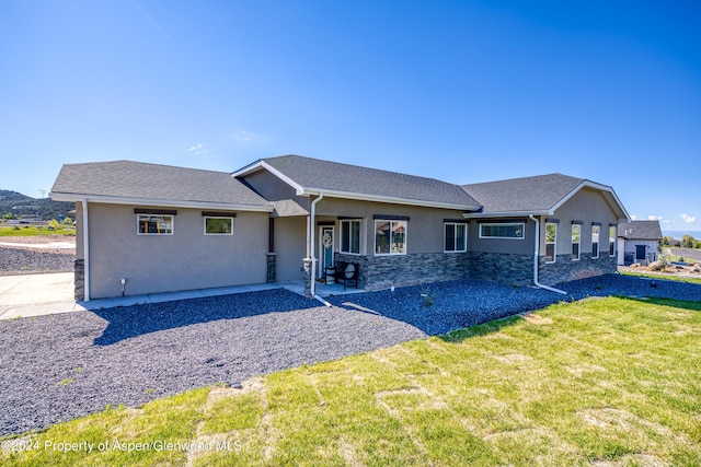 view of front of house with a patio and a front yard