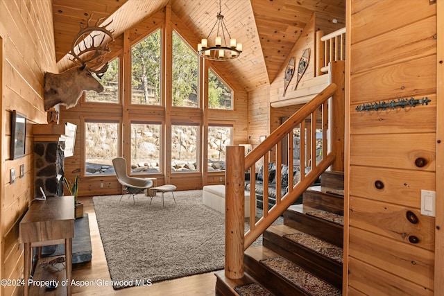 living room with an inviting chandelier, high vaulted ceiling, wood walls, wood-type flooring, and wood ceiling