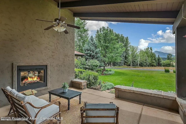 289 Sweetgrass Dr, Carbondale, CO 81623 - view of patio / terrace featuring a warm lit fireplace, a mountain view, and ceiling fan