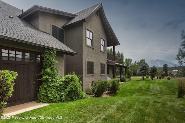 289 Sweetgrass Dr, Carbondale, CO 81623 - view of property exterior with a shingled roof, a mountain view, a yard, and stucco siding