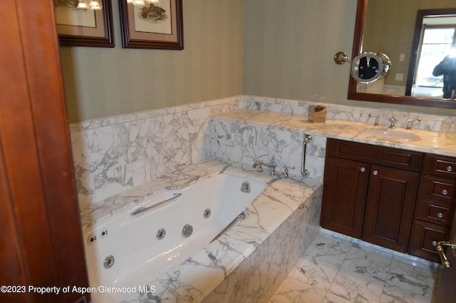 bathroom with vanity and tiled tub