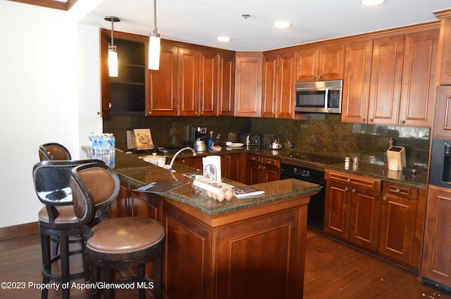 kitchen with pendant lighting, black appliances, decorative backsplash, dark hardwood / wood-style flooring, and a breakfast bar area