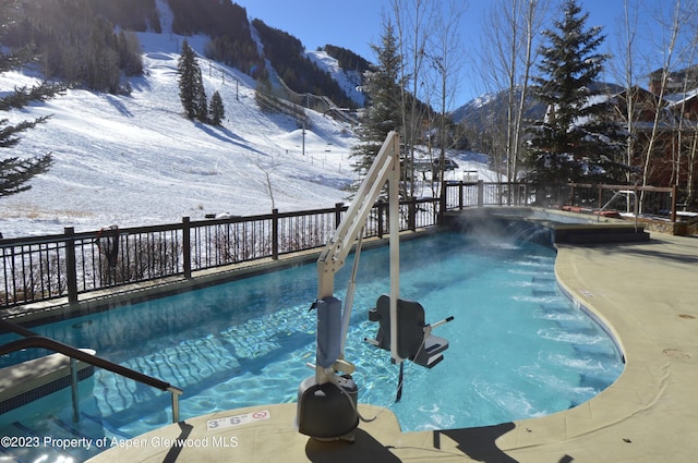 snow covered pool with a mountain view