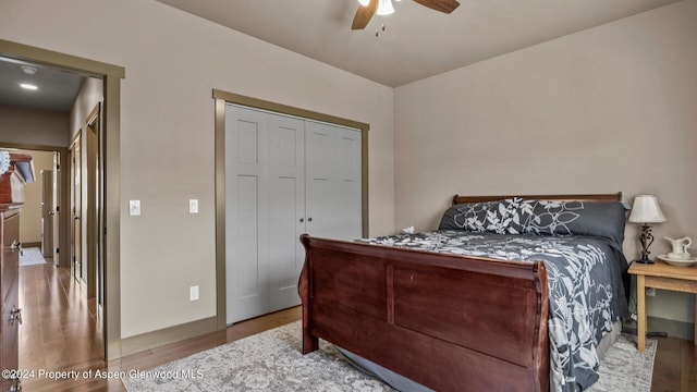 bedroom featuring ceiling fan, wood-type flooring, and a closet