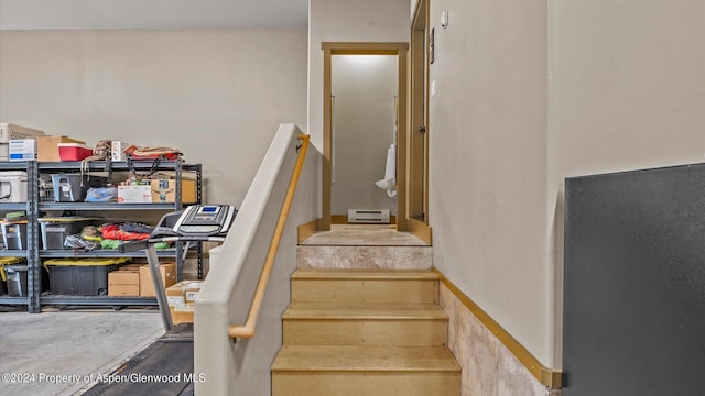 stairway with concrete flooring and a baseboard radiator