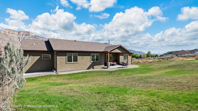 rear view of property featuring a yard and a patio