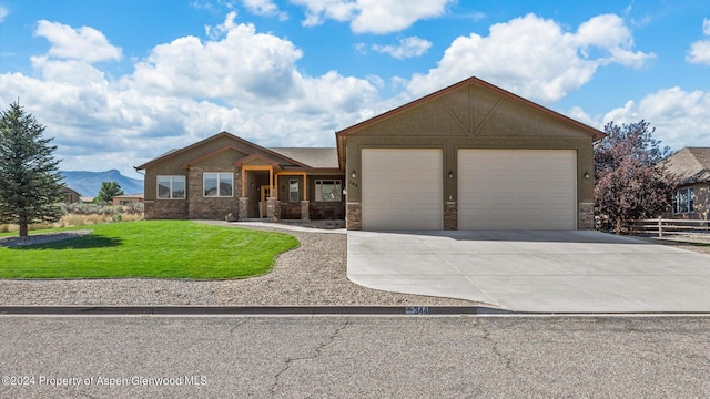 view of front of home with a mountain view, a garage, and a front lawn