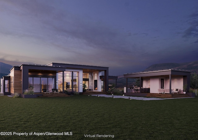 back house at dusk with a yard and a patio area