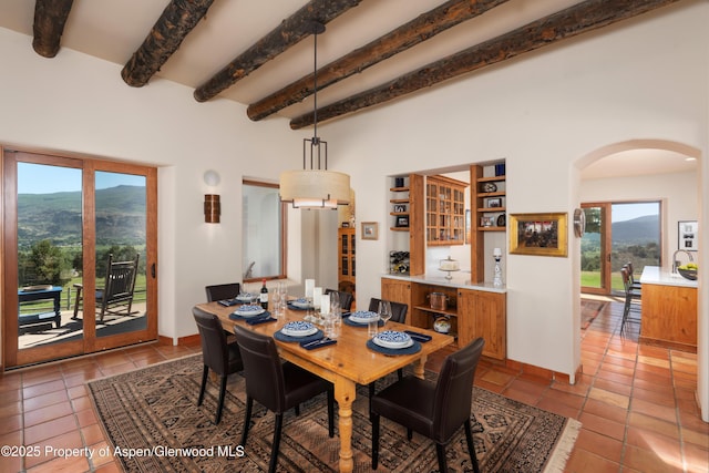 1432 Hooks Spur Rd, Basalt, CO 81621 - tiled dining space with arched walkways, beam ceiling, healthy amount of natural light, and a mountain view