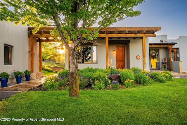 1432 Hooks Spur Rd, Basalt, CO 81621 - adobe home with a front yard, a pergola, and stucco siding
