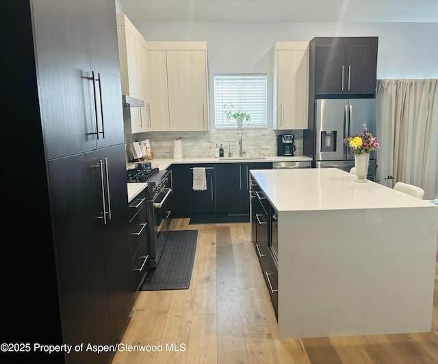 88 Green Mesa Pl, Parachute, CO 81635 - kitchen with stainless steel appliances, a sink, light wood-type flooring, light countertops, and tasteful backsplash