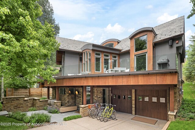 63 Smuggler Grove Rd, Aspen, CO 81611 - view of front of property featuring a garage, a balcony, stone siding, and driveway