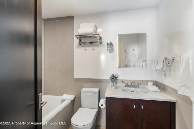 63 Smuggler Grove Rd, Aspen, CO 81611 - full bath featuring vanity, a bathtub, and tile walls