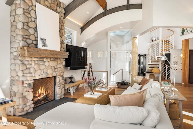 63 Smuggler Grove Rd, Aspen, CO 81611 - living room featuring wood finished floors, a fireplace, stairs, high vaulted ceiling, and arched walkways