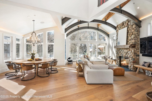 63 Smuggler Grove Rd, Aspen, CO 81611 - living area with light wood-style floors, a stone fireplace, a chandelier, high vaulted ceiling, and recessed lighting