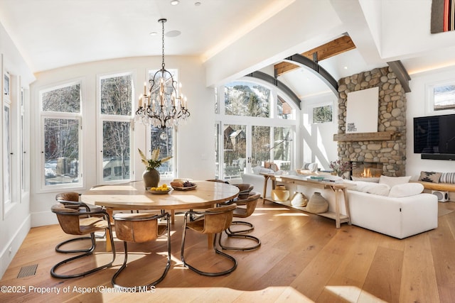 63 Smuggler Grove Rd, Aspen, CO 81611 - dining area featuring light wood-type flooring, a stone fireplace, and a chandelier