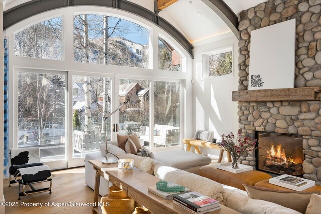 63 Smuggler Grove Rd, Aspen, CO 81611 - living room with high vaulted ceiling, a fireplace, wood finished floors, beam ceiling, and arched walkways