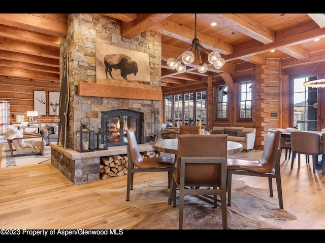 dining area with a stone fireplace, wood-type flooring, wooden ceiling, and a notable chandelier