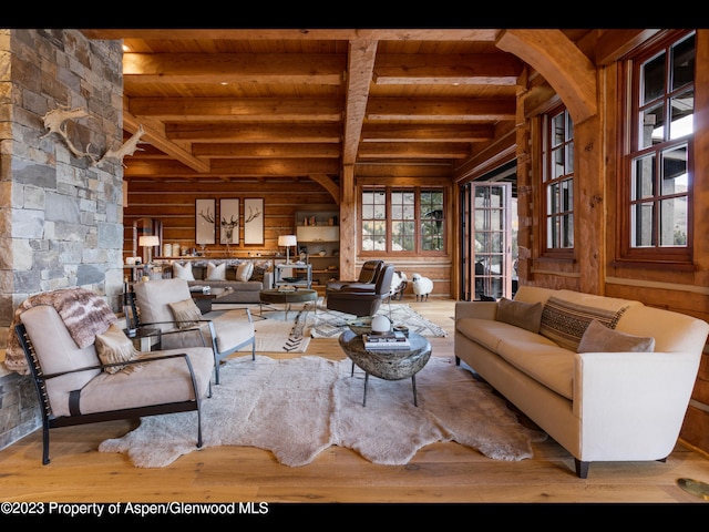 living room featuring wood walls, beamed ceiling, wood ceiling, and light hardwood / wood-style floors