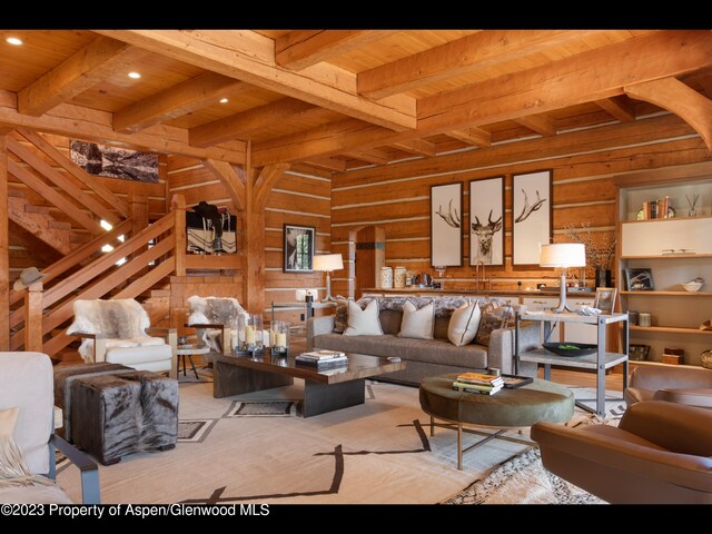 living room with wood walls, wooden ceiling, and beam ceiling