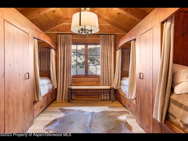 mudroom featuring wooden ceiling, lofted ceiling, an inviting chandelier, wooden walls, and light hardwood / wood-style floors