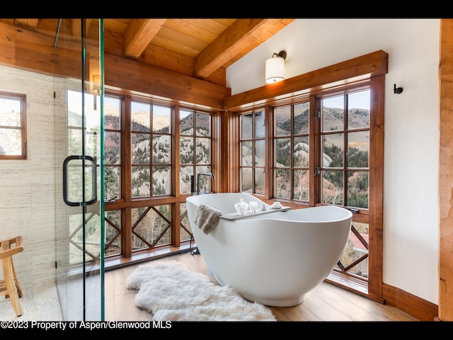 bathroom featuring lofted ceiling with beams, a bathtub, wooden ceiling, and hardwood / wood-style flooring