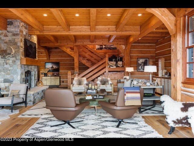 living room featuring beam ceiling, light hardwood / wood-style flooring, and wooden ceiling