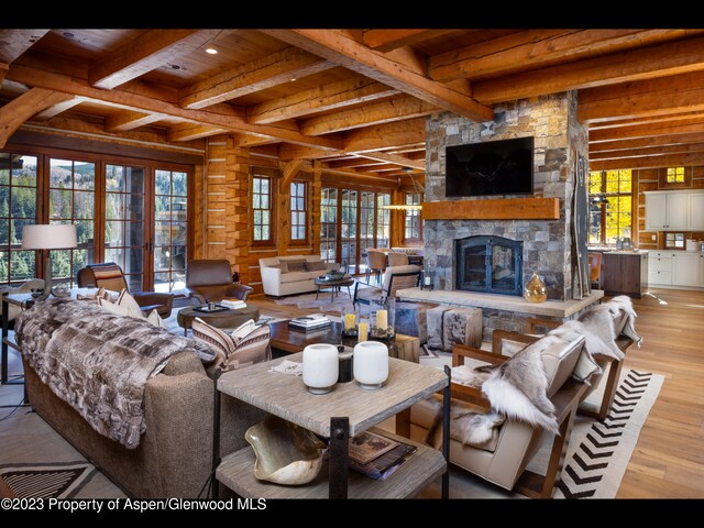 living room featuring a fireplace, light hardwood / wood-style flooring, plenty of natural light, and beamed ceiling