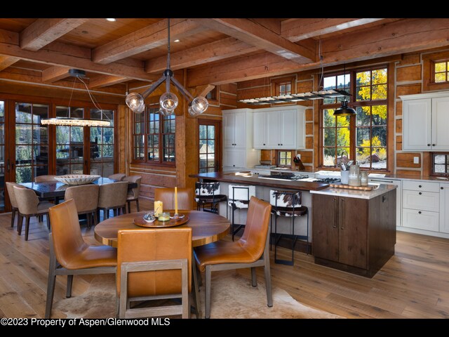 dining area with wooden ceiling, french doors, light hardwood / wood-style flooring, beamed ceiling, and a notable chandelier