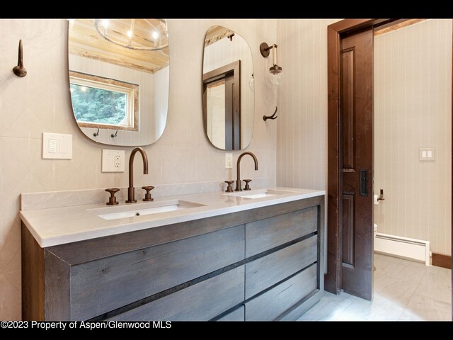 bathroom featuring vanity, baseboard heating, and tile walls