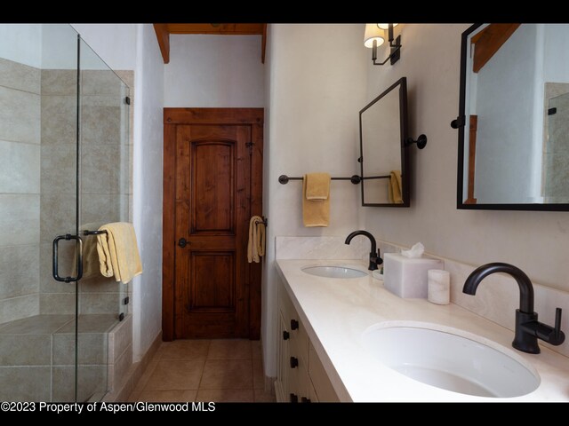 bathroom with tile patterned flooring, vanity, and an enclosed shower