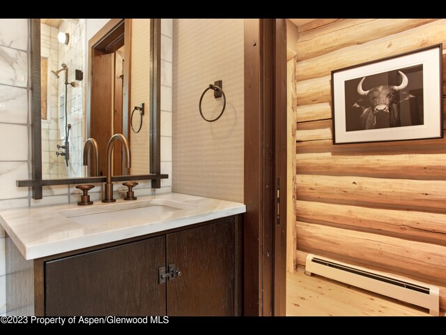 bathroom with vanity, rustic walls, and a baseboard radiator