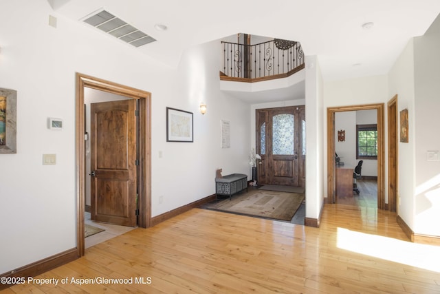 foyer entrance featuring light wood-type flooring and a high ceiling