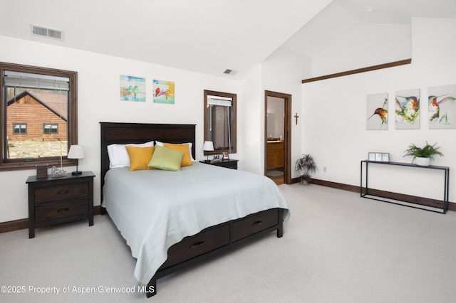 bedroom featuring light colored carpet, ensuite bath, and vaulted ceiling