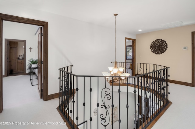 stairway featuring an inviting chandelier and carpet flooring