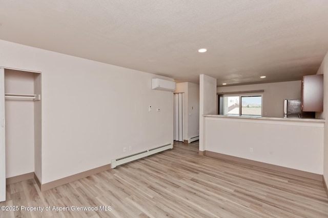 109 Anna Ct Unit B8, Grand Junction, CO 81503 - unfurnished living room featuring baseboard heating, a wall mounted AC, light wood finished floors, and recessed lighting