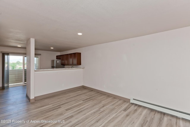 109 Anna Ct Unit B8, Grand Junction, CO 81503 - unfurnished living room featuring a baseboard radiator, light wood-type flooring, and recessed lighting