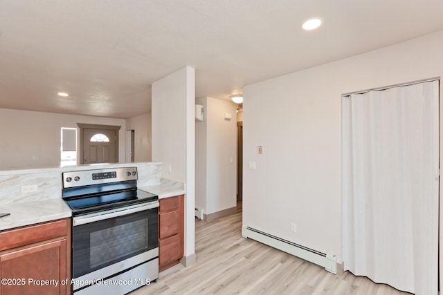 109 Anna Ct Unit B8, Grand Junction, CO 81503 - kitchen with stainless steel electric range oven, baseboard heating, light wood finished floors, light countertops, and brown cabinets