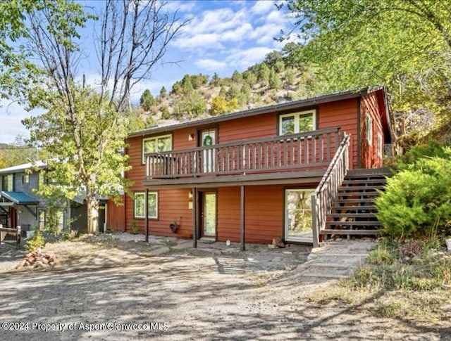 rear view of house featuring a wooden deck