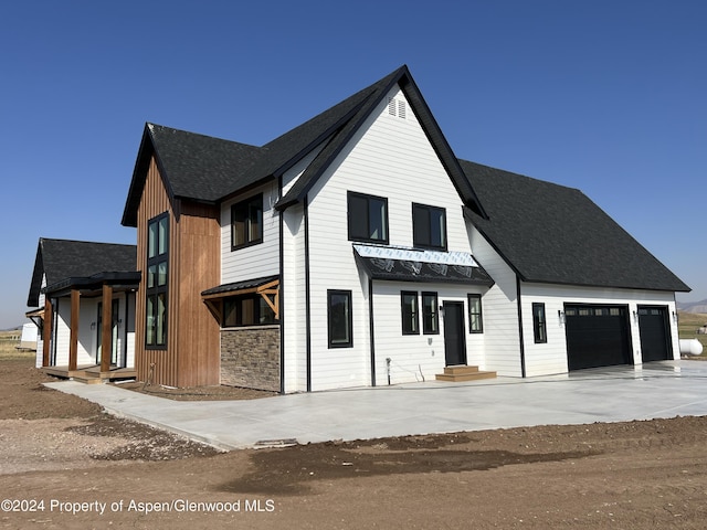 modern inspired farmhouse with a garage