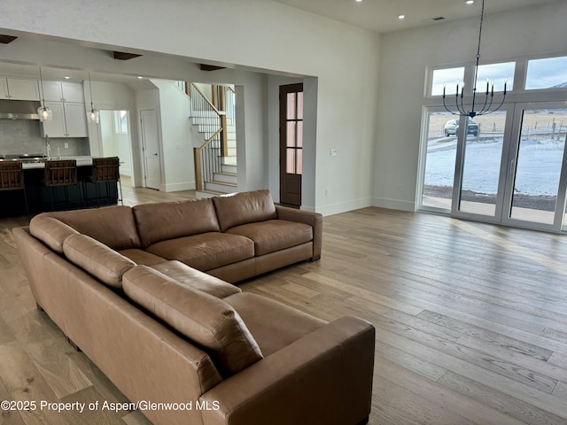 living room with light hardwood / wood-style floors, a notable chandelier, and sink