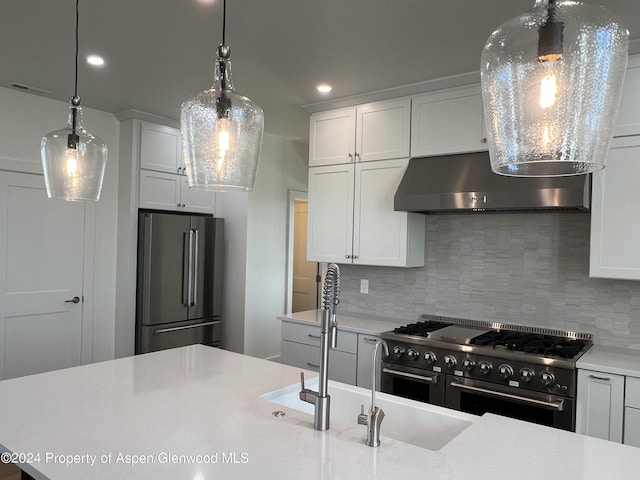 kitchen with backsplash, wall chimney exhaust hood, white cabinetry, and stainless steel appliances