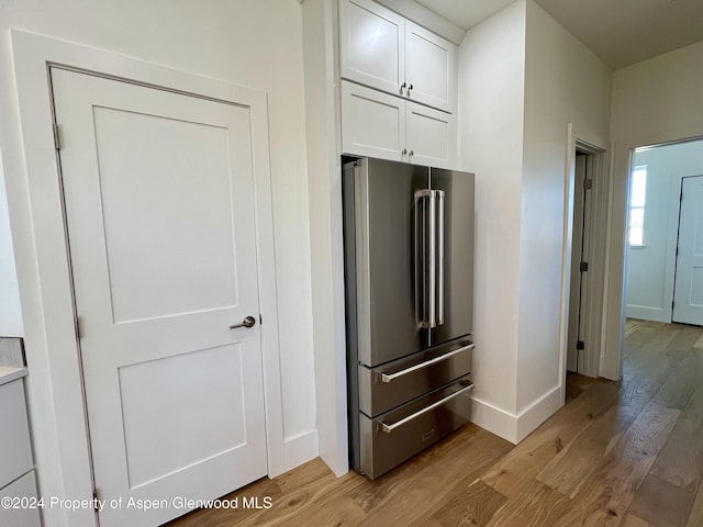 kitchen with white cabinets, light hardwood / wood-style floors, and high end refrigerator