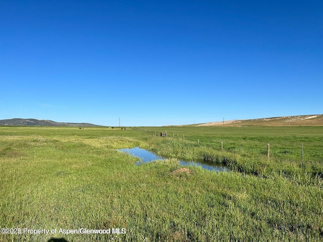 view of yard with a water view and a rural view