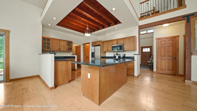 148 Laird Ln, Glenwood Springs, CO 81601 - kitchen with appliances with stainless steel finishes, a high ceiling, brown cabinetry, a wooden ceiling with exposed beams, and a kitchen island