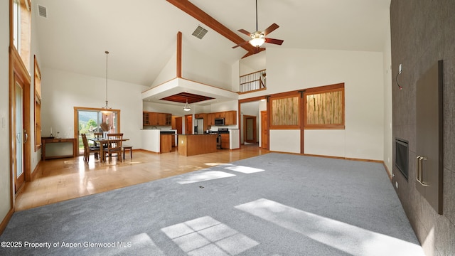 148 Laird Ln, Glenwood Springs, CO 81601 - living room featuring high vaulted ceiling, light carpet, a large fireplace, ceiling fan, and beamed ceiling